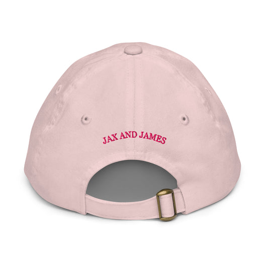 Back view of a light pink kids baseball hat with embroidered Jax and James lettering above the adjustable strap